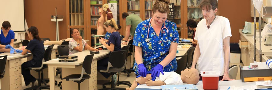 Instructor Monika Bell working with a medical assisting student in the classroom.